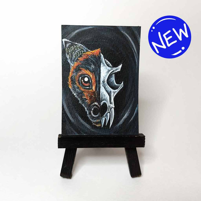 

an illustration split into two sides, a flying fox's face on the left and a creepy bat skull on the right. available as an art print