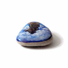 Load image into Gallery viewer, a small beach stone, hand painted with a portrait of a brindle french bulldog, as an angel in the clouds.
