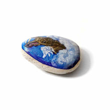 Load image into Gallery viewer, a small beach stone, hand painted with a portrait of a brindle french bulldog, as an angel in the clouds.
