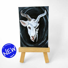 Load image into Gallery viewer, an aceo features a split image: a white horned goat&#39;s head on the left side, and a darker, stylized goat skull on the right
