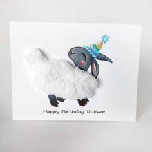 Load image into Gallery viewer, a greeting card featuring an illustration of a smiling black sheep with white fleece, wearing a rainbow party hat. its fleece is made with thick, chunky, white yarn. the front reads, &quot;Happy Birthday to Ewe!&quot;
