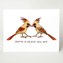 Load image into Gallery viewer, a greeting card featuring an illustration of two cardinals, two female, beaks just touching. it reads, &quot;Home is where you are&quot;. 
