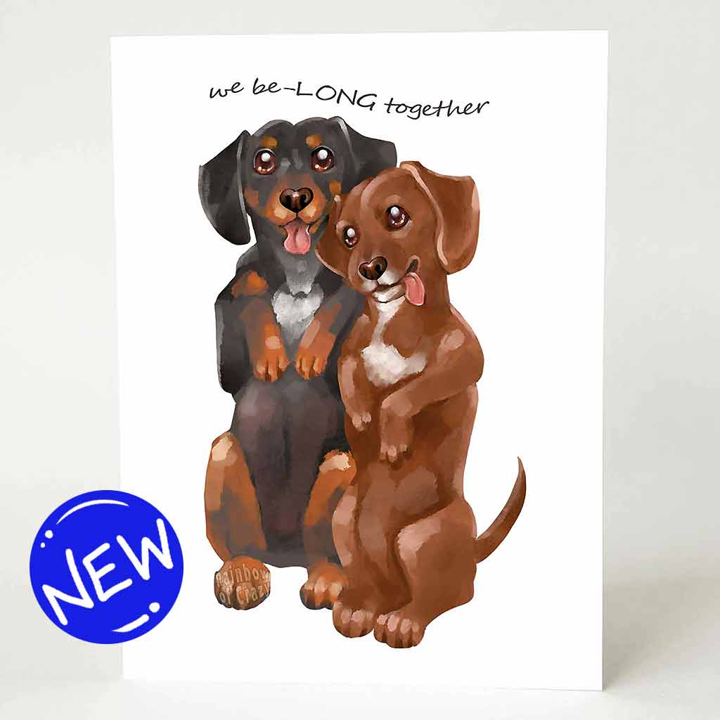 a greeting card with an illustration of one black dachshund, and one brown dachshund, both standing up on their hind legs. it reads, 