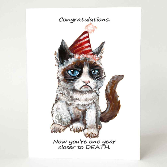 a greeting card, illustrated with a grumpy cat wearing a birthday hat. the front reads, 