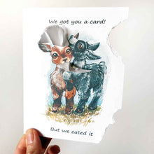 Load image into Gallery viewer, a funny greeting card with two goats: a brown goat and a black goat, on the front, with the piece from the top right, and piece from the bottom right corner of the card ripped and hanging from their mouths. the card reads, &quot;We got you a card! But we eated it&quot;
