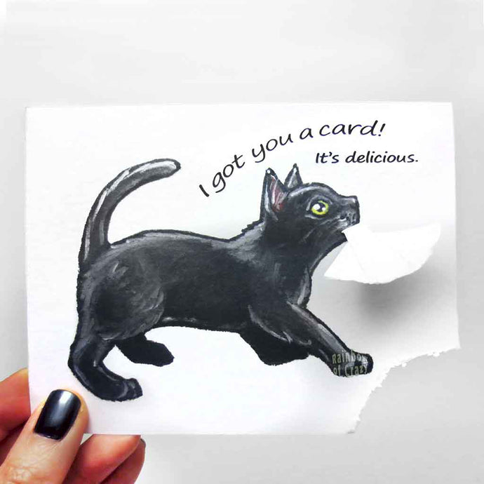 a greeting card, illustrated with a black cat. the bottom right corner of the card has been ripped and hangs from the cat's mouth. card reads, 