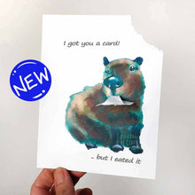 Load image into Gallery viewer, a greeting card illustrated with a capybara. the top right corner of the card has been ripped out and hangs from the capybara&#39;s mouth. the card says &quot;I got you a card! .. but I eated it&quot;
