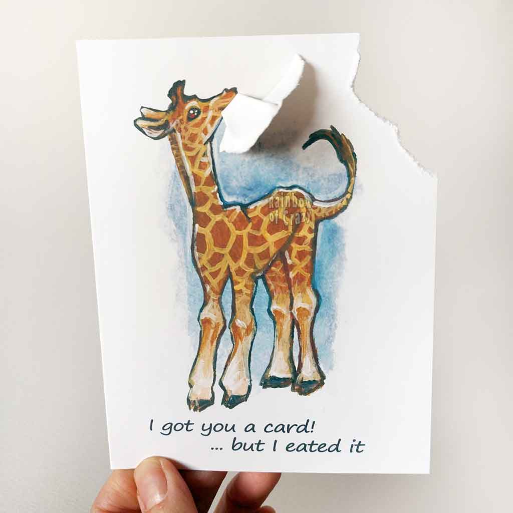 greeting card, featuring art of a giraffe. a corner of the card is ripped off and hangs from its mouth. Text reads, I got you a card! .. but I eated it