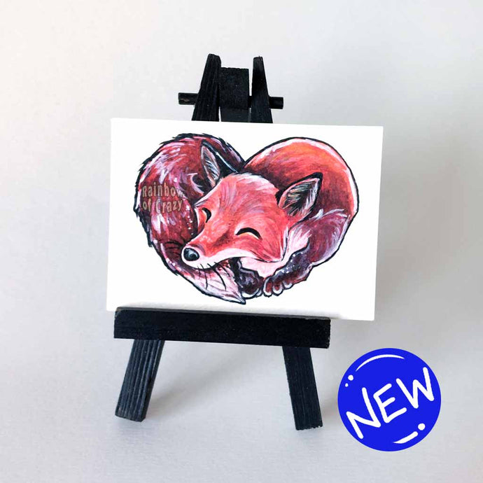 An ACEO sized painting of a red fox, curled up in the shape of a heart. 