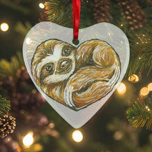 Load image into Gallery viewer, a heart shaped glass ornament, featuring an illustration of a sloth, curled up in the shape of a heart 
