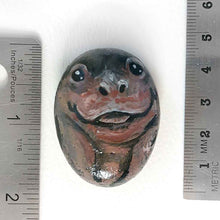 Load image into Gallery viewer, a small beach stone painted to looke like a smiling baby hippo
