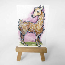 Load image into Gallery viewer, aceo sized painting of a smiling llama against a soft purple and green background. the painting rests on a small wood easel
