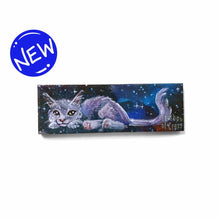 Load image into Gallery viewer, small wood rectangle fridge magnet, hand painted with a portrait of a fluffy cat painted in purples, blues, and grays, lying down against a galaxy background of stars
