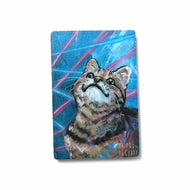 small wood rectangle fridge magnet, hand painted with a portrait of a brown tabby cat looking up with a smile, posing in front of a retro 80s / 90s blue background with blue and pink lasers