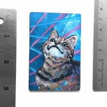 Load image into Gallery viewer, small wood rectangle fridge magnet, hand painted with a portrait of a brown tabby cat looking up with a smile, posing in front of a retro 80s / 90s blue background with blue and pink lasers
