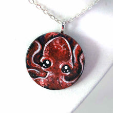 Load image into Gallery viewer, a lightweight wood disc, hand painted with a portrait of a red baby octopus. the painting is available as a keepsake, or pendant necklace
