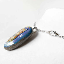 Load image into Gallery viewer, an oval shaped beach stone, hand painted with the portrait of an orange munchkin cat as an angel. standing up on clouds against a royal blue sky. available at a keepsake or pendant necklace
