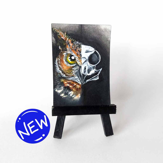 an aceo sized painting, split into two sides, a great horned owl's face on the left and a creepy owl skull on the right.
