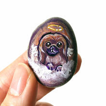 Load image into Gallery viewer, A portrait painting of a Pekingese dog as an angel with wings, painted on a small rock, available as a keepsake, fridge magnet, or pendant necklace

