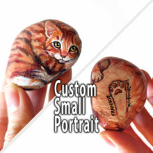 Load image into Gallery viewer, small beach stone, custom painted with a portrait of an orange tabby cat
