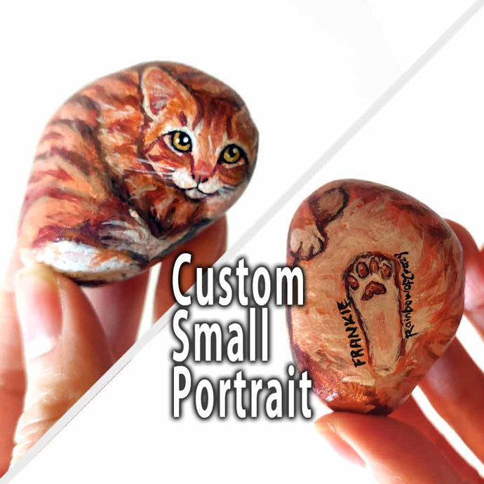 small beach stone, custom painted with a portrait of an orange tabby cat