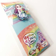 Load image into Gallery viewer, acrylic glitter pin featuring an illustration of a mini lop rabbit hugging a book, with a tiny heart next to him. packaging includes other characters from Rainbow of Crazy Comics
