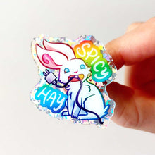 Load image into Gallery viewer, sparkly acrylic pin of a smiling white rabbit holding a charging cable in her mouth, with the words "SPICY HAY in rainbow colours.

