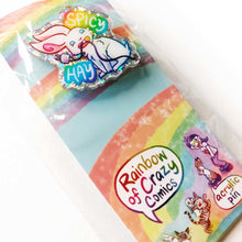Load image into Gallery viewer, sparkly acrylic pin of a smiling white rabbit holding a charging cable in her mouth, with the words "SPICY HAY in rainbow colours. packaged with a backing board featuring more Rainbow of Crazy Comic characters

