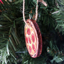 Load image into Gallery viewer, side view of a wood ornament hanging on a christmas tree, painted to look like a pepperoni pizza
