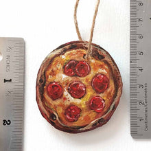 Load image into Gallery viewer, wood ornament hanging on a christmas tree, painted to look like a pepperoni pizza, shown next to rulers for size
