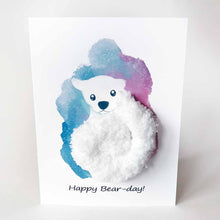 Load image into Gallery viewer, a greeting card with an illustration of a polar bear. thick, fluffy white yarn makes up the bear&#39;s body. the background has a splash of blue and purple. the front says, &quot;Happy Bear-day!&quot;
