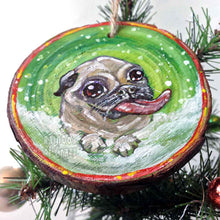 Load image into Gallery viewer, a wood ornament, hand painted with a pug in the snow, tongue out, ready to catch snowflakes
