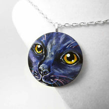 Load image into Gallery viewer, A wood pendant necklace, painted with the portrait of a cat in dark purple and black
