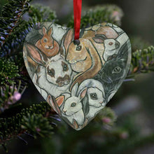 Load image into Gallery viewer, a heart shaped glass ornament, printed with a collage of different rabbit breeds
