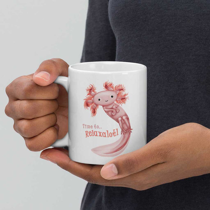 hands holding a white ceramic mug, 11 oz size, with an illustration of a smiling axolotl next to the text 