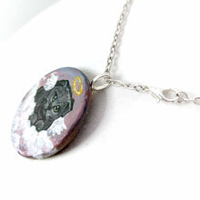 Load image into Gallery viewer, a small wood circle, hand painted with the portrait of a dark gray scottish fold cat, as an angel, with halo and wings, sitting on clouds against a pink and purple sky. available as a wood keepsake or pendant necklace
