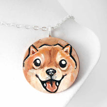 Load image into Gallery viewer, small wood disc painted with a smiling Shiba inu&#39;s face. available as a keepsake or pendant necklace 
