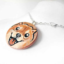 Load image into Gallery viewer, small wood disc painted with a smiling Shiba inu&#39;s face. available as a keepsake or pendant necklace 
