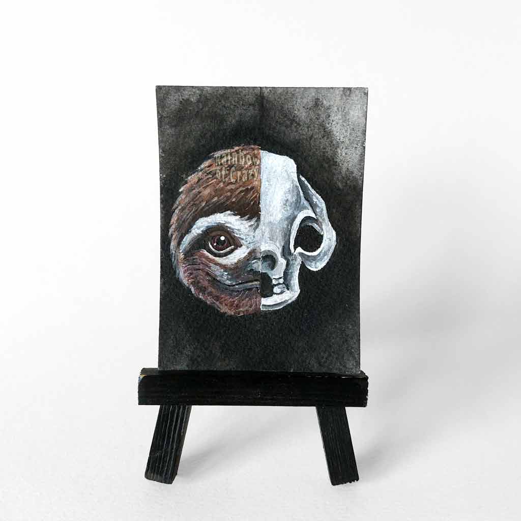 ACEO painting split into two halves: one side featuring a sloth’s smiling face, the other, an eerie sloth skull.