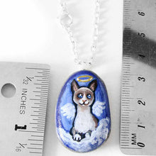 Load image into Gallery viewer, a small beach stone hand painted with the portrait of a snowshoe cat, as an angel on the clouds. available as a keepsake or pendant necklace
