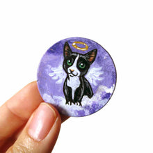 Load image into Gallery viewer, a portrait of a tuxedo cat as an angel, sitting on clouds against a purple sky, painted on a small wood disc, available as a keepsake or pendant necklace
