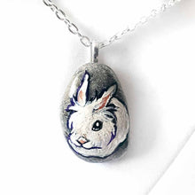 Load image into Gallery viewer, a small beach stone, hand painted with a portrait of a white lionhead rabbit. available as a keepsake or pendant necklace
