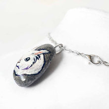 Load image into Gallery viewer, a small beach stone, hand painted with a portrait of a white lionhead rabbit. available as a keepsake or pendant necklace
