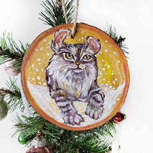 Load image into Gallery viewer, A wooden ornament with art of an American Curl cat with golden eyes, watching the snow fall
