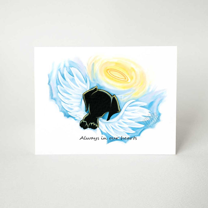 A greeting card with a black dog angel on the front, that reads, 