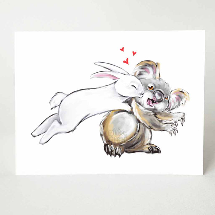 a greeting card of a white rabbit leaping onto a surprised koala and giving it kisses