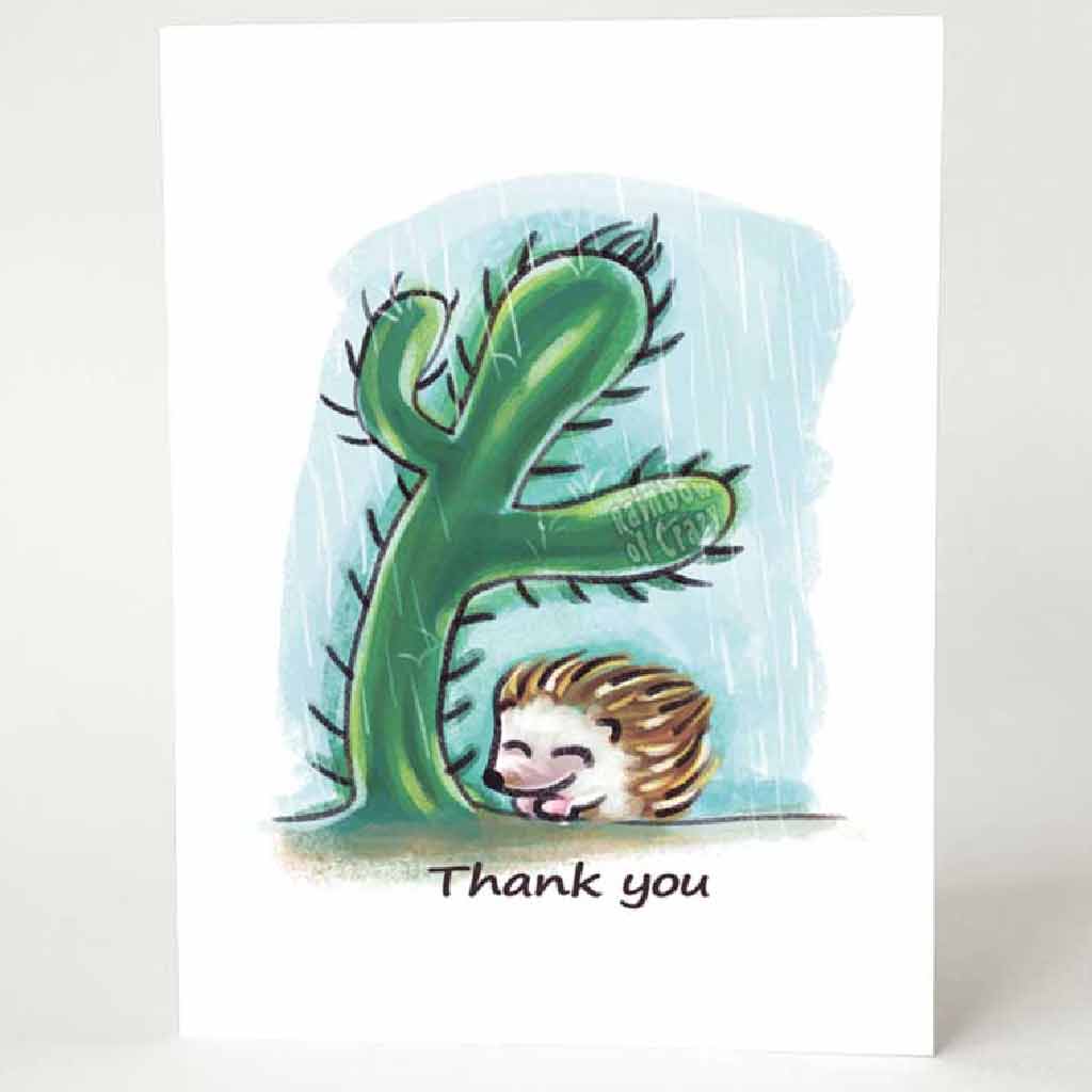 a greeting card with a hedgehog under a cactus, getting protection from the rain. the card reads, 