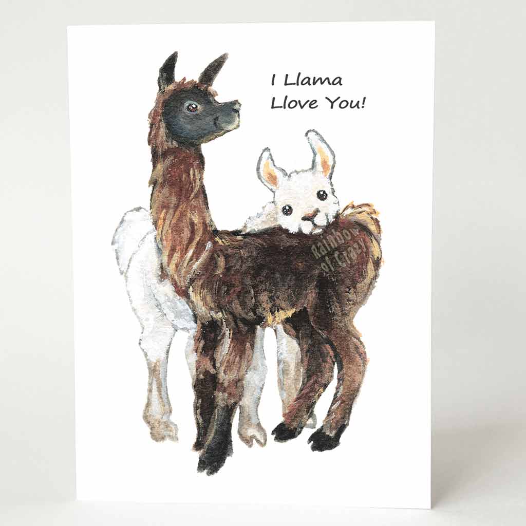 A greeting card with an illustration of a white llama resting its head on a brown llama's back, and the words, 