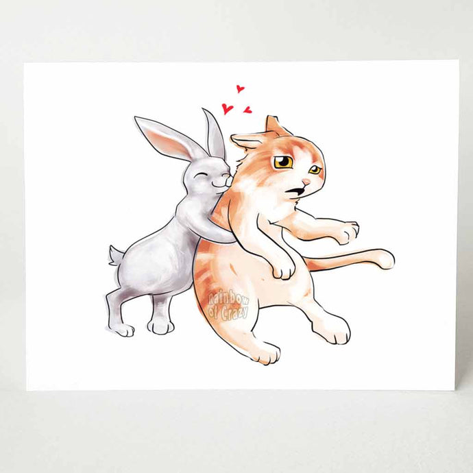 a greeting card with an illustration of a white rabbit giving a giant hug to a surprised orange cat