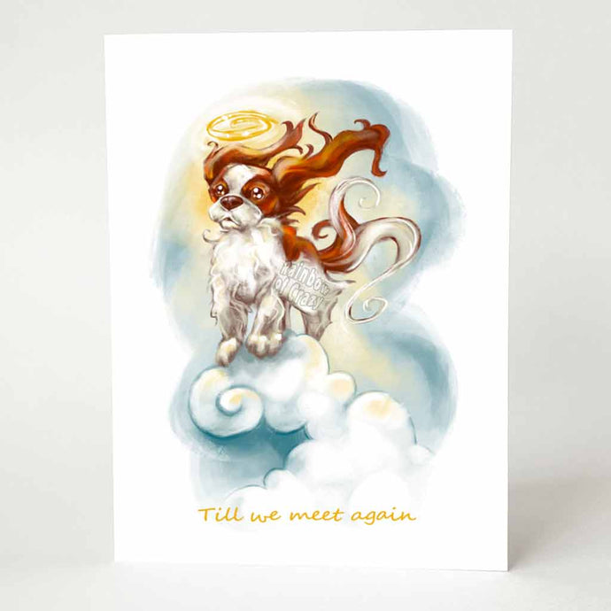 A greeting card featuring art of a Cavalier King Charles Spaniel angel, with a halo over its head. It stands on top of clouds with the wind blowing through its fur, and reads, 